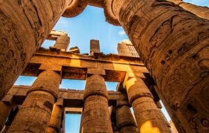 View of the majestic ancient columns in Karnak Temple, Egypt, under a clear sky.